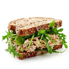 Tuna salad sandwich with lettuce and arugula on whole grain bread on white background.
