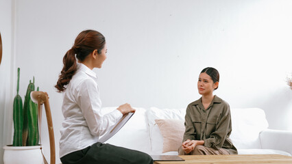 Sad PTSD woman patient in therapy for mental health with psychologist, depression or grief after...
