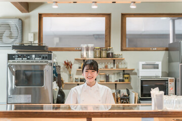 カフェ・居酒屋・飲食店の厨房で働く調理師のアジア人女性
