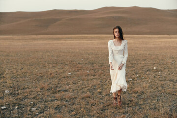 Woman in white dress standing in the middle of an open grassy field a serene moment of beauty and...