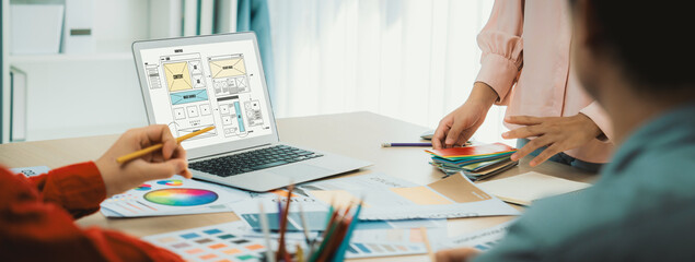 Cropped image of interior designer team discuss the material color while laptop displayed website...