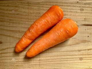 木のテーブルに乗せたニンジン２本