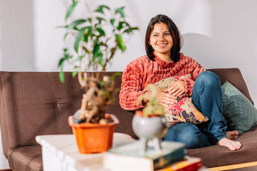 Latin American woman sitting on the sofa with a positive attitude