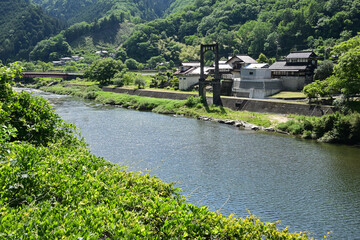 川岸に残る廃吊り橋の主橋脚のある風景