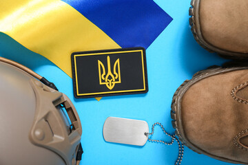 Badge with trident, military boots, tactical helmet and flag of Ukraine on blue background