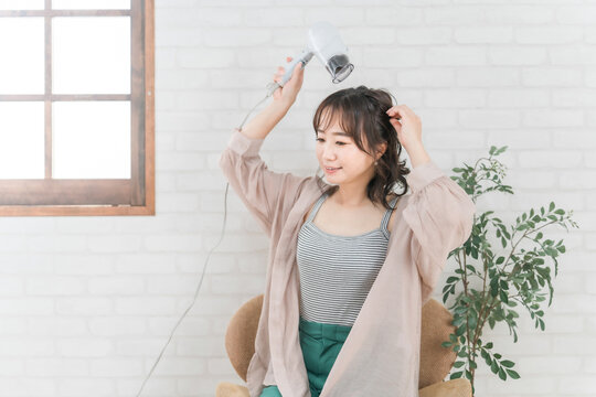 部屋でドライヤーを使ってヘアブローする女性ドライヤー, ヘアケア, 髪の毛, 乾かす, 女性, ヘア
