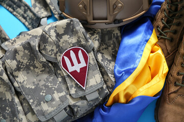 Unloading vest with military badge of Ukrainian army, Ukraine flag, boots and tactical helmet on...