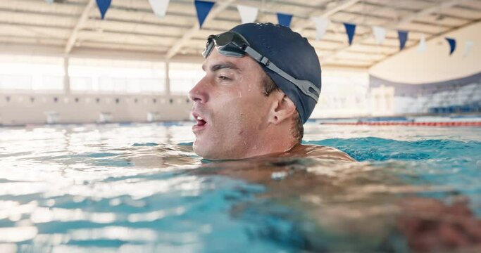 Man, breathing and tired from swimming in pool, exercise and fitness for sport. Male athlete, workout and recovery in water for health or wellness, strong with pause for cardio or aerobic training