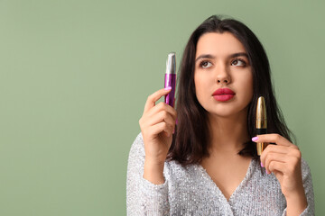 Fototapeta premium Beautiful young woman with stylish mascara on green background