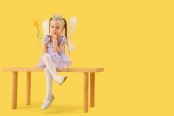 Cute little fairy sitting on bench against yellow background