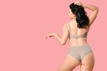 Beautiful young body positive woman in stylish underwear on pink background, back view