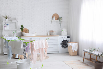 Interior of laundry room with washing machine, basket and dryer