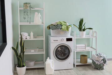 Interior of laundry room with washing machine, baskets and shelf units
