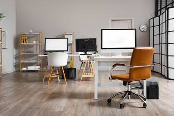 Modern workplaces with computer monitors in light office