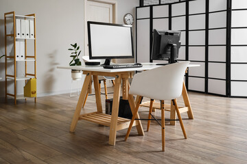 Modern desk with computer monitors in light office