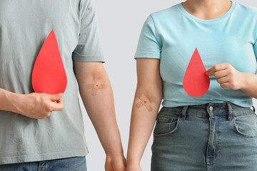 Donors with applied medical patches and paper blood drops on grey background