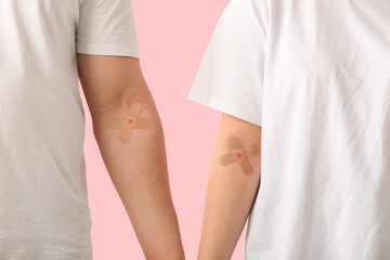 Blood donors with applied medical patches on pink background, closeup