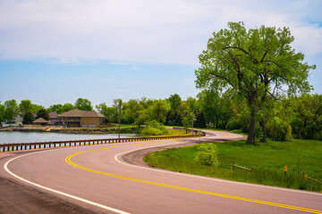 Entering the Wall Lake in Hartford, Minnehaha County, South Dakota: The curving paved road with...