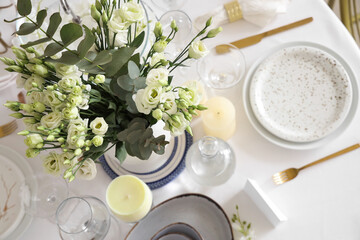 Beautiful table setting with white flowers and candles for wedding celebration in room, top view