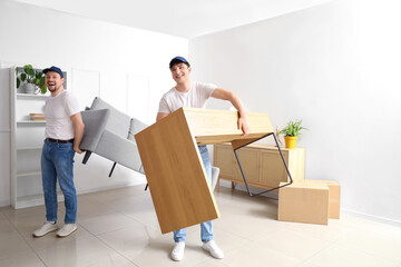 Fototapeta na wymiar Loaders carrying furniture in room