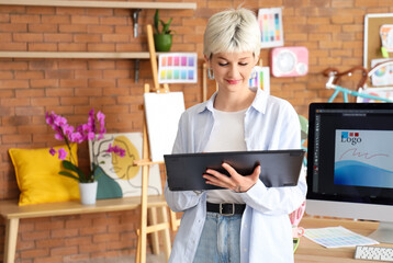 Female graphic designer working with tablet in office
