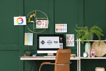 Graphic designer's workplace with computer monitor and color palettes in office