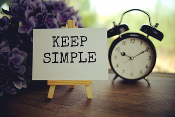 Keep simple text message text message on paper card with wooden easel on wooden table background,...