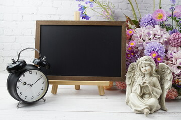 Empty chalkboard mock up space for text message with flower bouquet and home decorations on wooden background