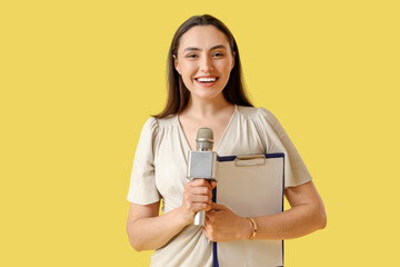 Female reporter with microphone and clipboard on yellow background