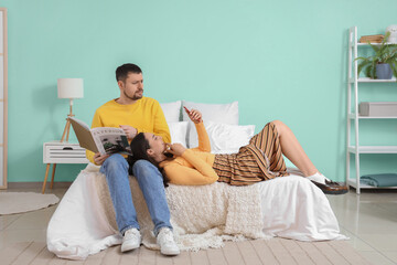 Young woman texting lover and her husband in bedroom. Cheating concept