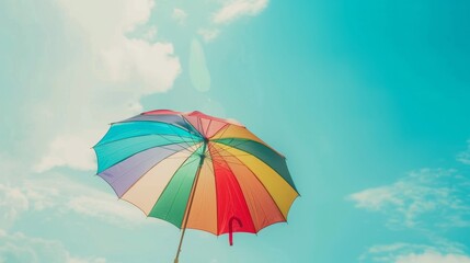 Vintage rainbow umbrella against blue sky