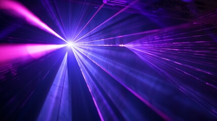 Blue and violet beams of laser light shine brilliantly against a black background, creating a dynamic and captivating visual effect. 