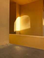Abstract yellow geometric architectural forms. Modern buildings in the sun with deep shadows. Ochre shades of plaster with 3D effects of lighting and shapes. Minimalism in architecture. No filters.