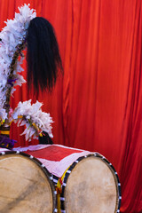 Dhak is a special drum or musical instrument played during durga puja festival. dhaks are kept together against red background.
