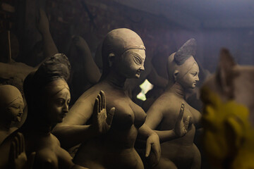 idol of goddess durga during durga puja festival. The unfinished idol is made of clay being...
