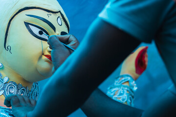 Goddess Durga idol's eyes being painted for Durga puja festival during mahalaya at kumartuli. This special occassion is known as chokkhu daan which marks the beginning of the hindu festival.