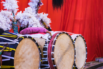 Dhak is a special drum or musical instrument played during durga puja festival. dhaks are kept together against red background.