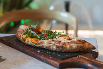 Fresh fire stone oven-baked pizza calzone with veggies 