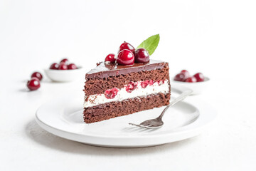 Delicious chocolate cake with cherries on a white plate