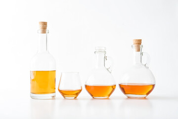 Glass Bottles with Golden Liquid on White Background