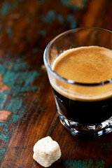 Coffee in glass cup on dark wooden background. Close up.	