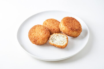 Coconut breaded cheese balls on a white plate