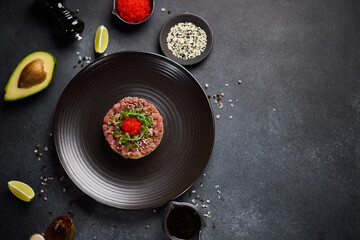 Tuna and avocado tartare on a dark ceramic plate