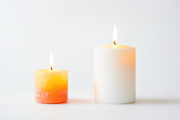 Two candles burning on white background