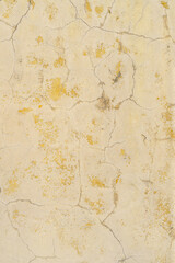 Yellow cracked paint on the wall. Abstract design background.