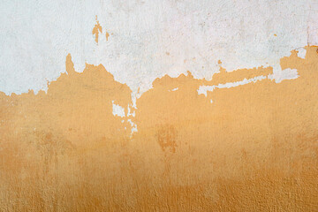 A beige wall is half painted with white paint. Abstract design background.