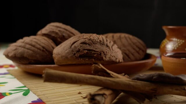 Chocolate conchas with cinnamon sticks on a mexican table