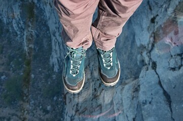 High angle view of the feet standing on transparent glass platform