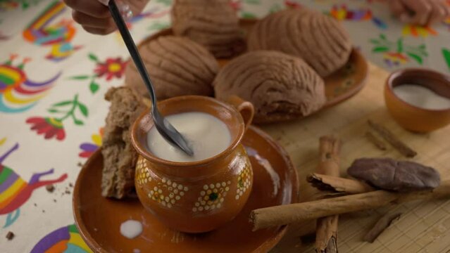 Foaming milk with mexican bread and cinnamon sticks in slow motion