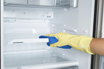 Employees use a cloth to clean the refrigerator..